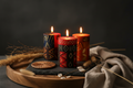 3 Bongazi candles colorully printed candles in earthy tones sitting on a stone slab atop a wooden tray. 