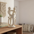 Hand-carved Kisii soapstone family sculpture of 2 parents and 3 children displayed on a wooden shelf in a boho home